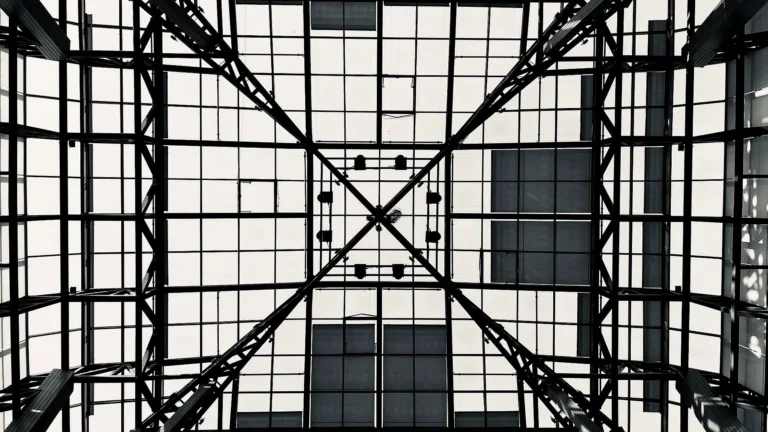 Structure géométrique en verre et acier illustrant la complexité d’un projet