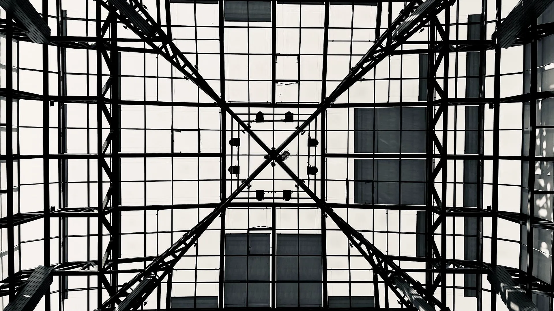 Structure géométrique en verre et acier illustrant la complexité d’un projet